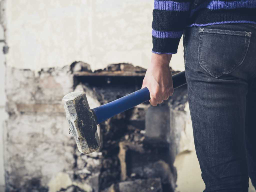 Ransomware Siege: Unlocking the Lockdown on Your VPN Weak Spots A young woman is opening up an old fireplace in a Victorian house with a sledge hammer
