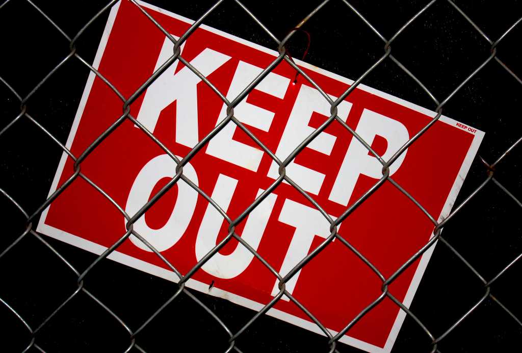 OpenAI’s Pioneering Transparency Initiative Uncovers Six New Misalignment Incidents in Debut Report Close up view of red keep out sign with white letters behind chain link fence. Dark background.